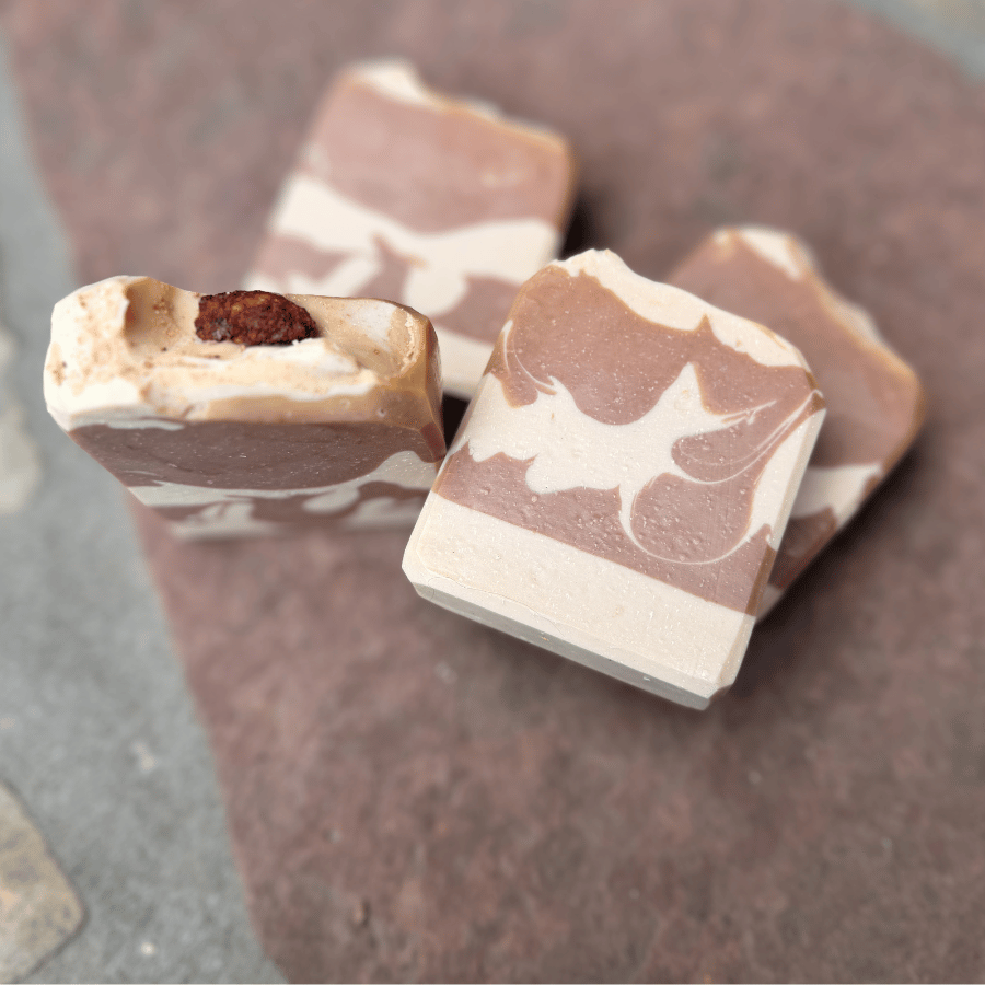 Close-up of Almond Cookie handcrafted tallow soap featuring marbled cocoa and cream layers, with a candied cinnamon almond topping.