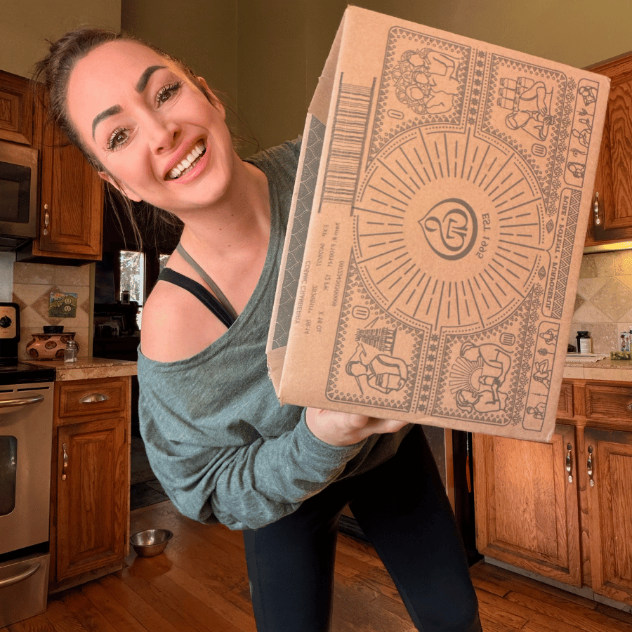Tallow Skin Co. founder smiling while holding a large mystery skincare gift box, featuring a surprise selection of handcrafted skincare, bath, and body care favorites.