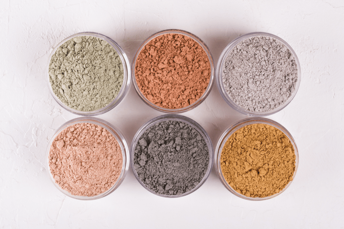 Different natural powders displayed on a white surface. 