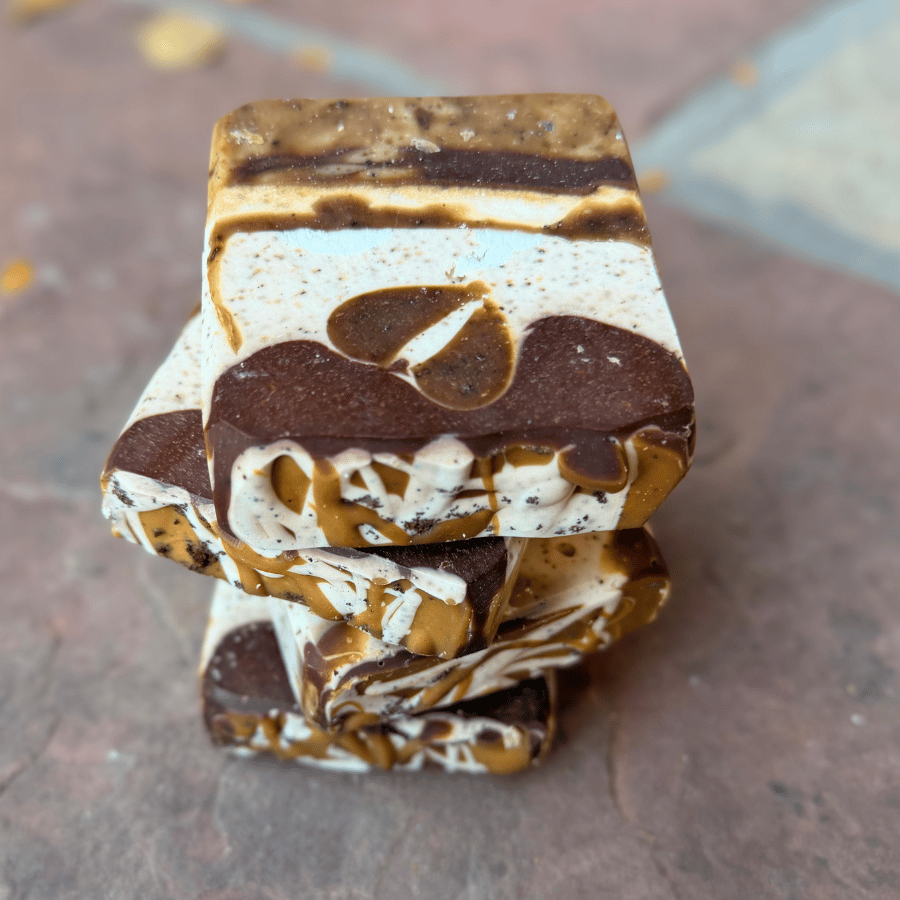 Close-up of layered chocolate coffee tallow soap with marbled caramel-colored swirls