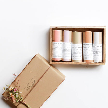 Three organic lip and cheek tint sticks alongside highlight and lowlight sticks