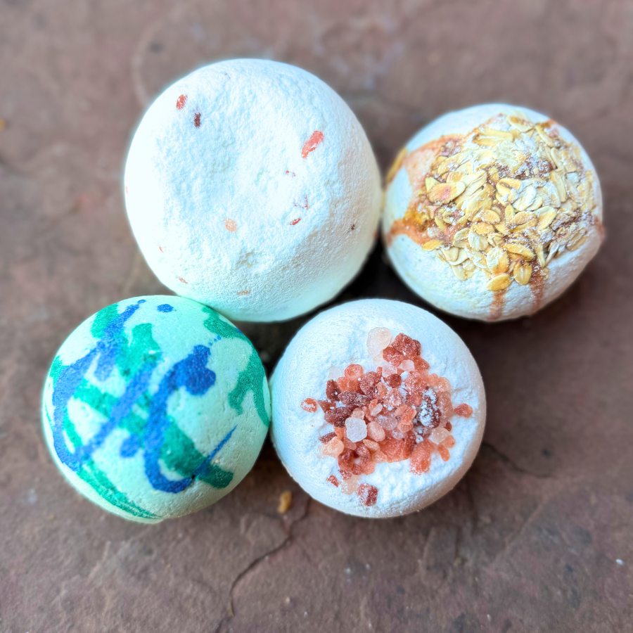 Dinosaur Surprise Bath Bomb displayed alongside three other colorful bath bombs from Tallow Skin Co.