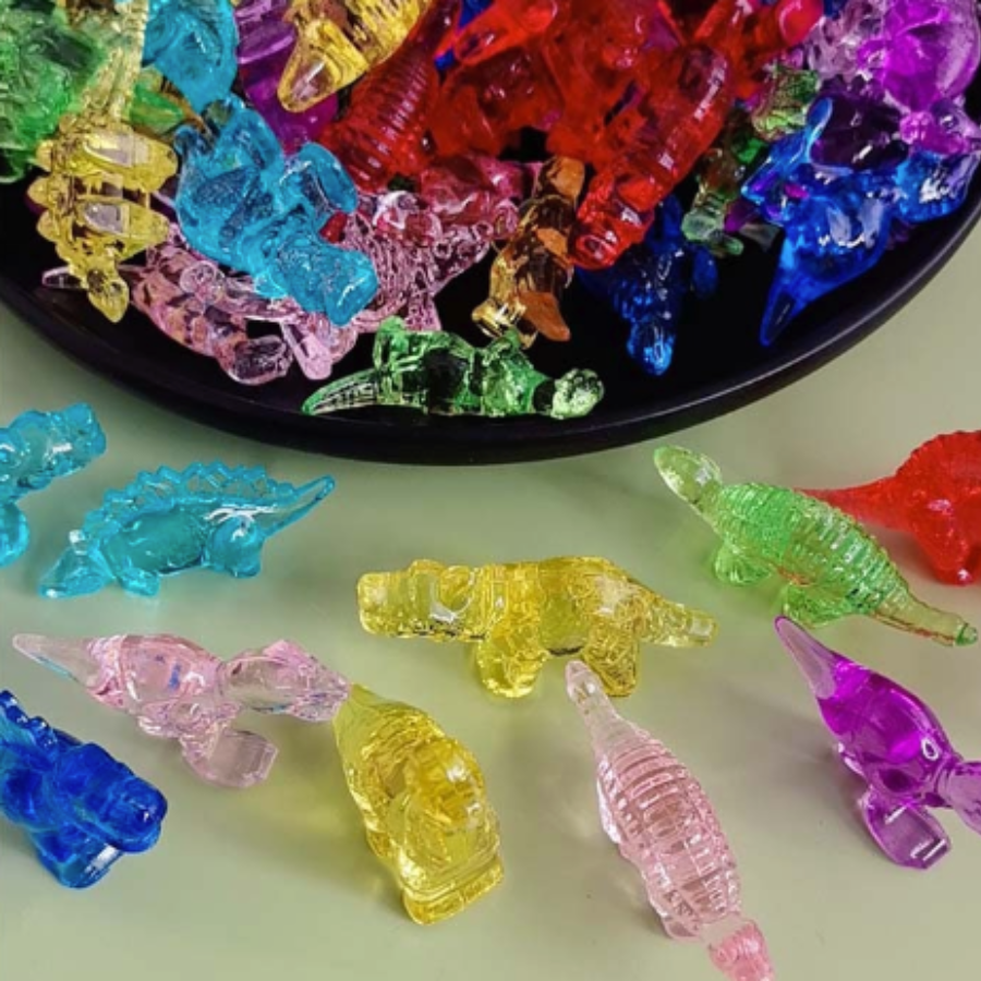 Assorted miniature translucent dinosaur surprises in colorful shades of blue, pink, green, yellow, purple, and red.