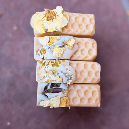 The Mary tallow soap bars arranged in a row, featuring cream-colored honeycomb details and pressed flowers