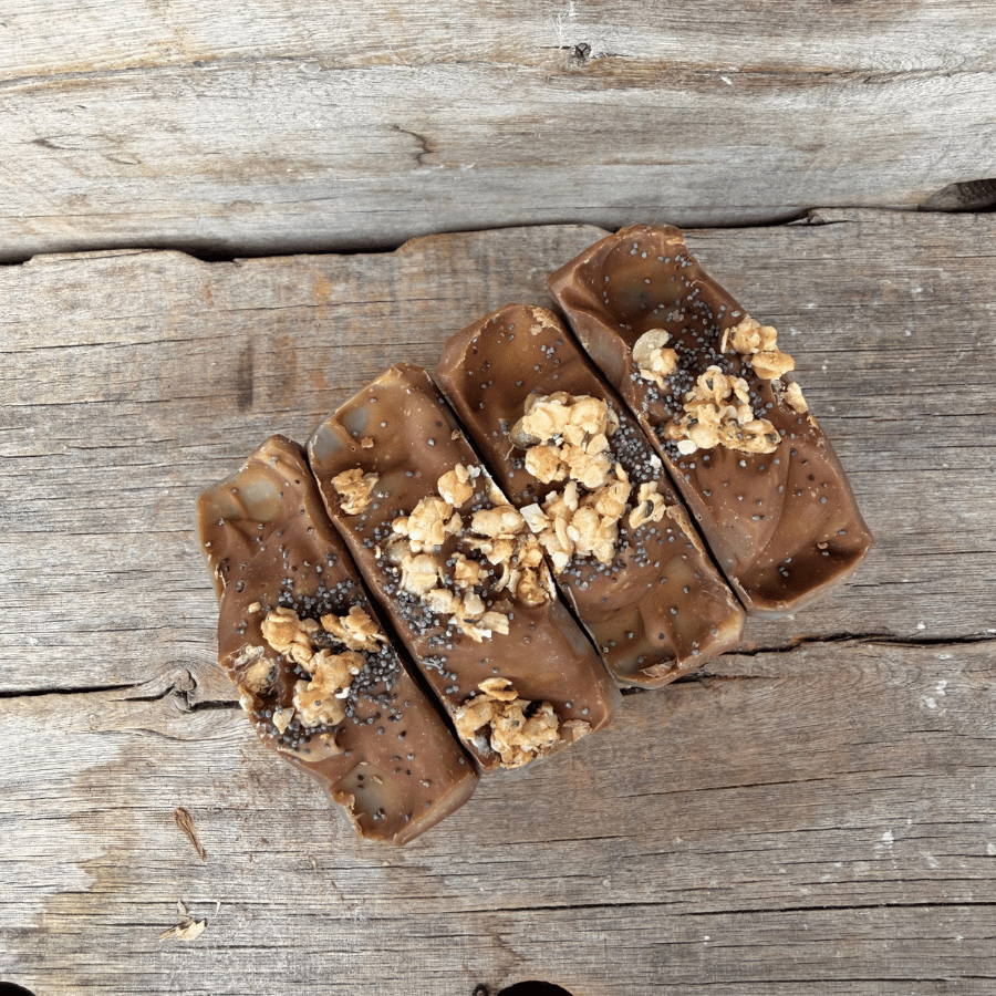 Overhead view of handmade Blueberry Muffin tallow soap topped with organic blueberry oat granola and poppy seeds.