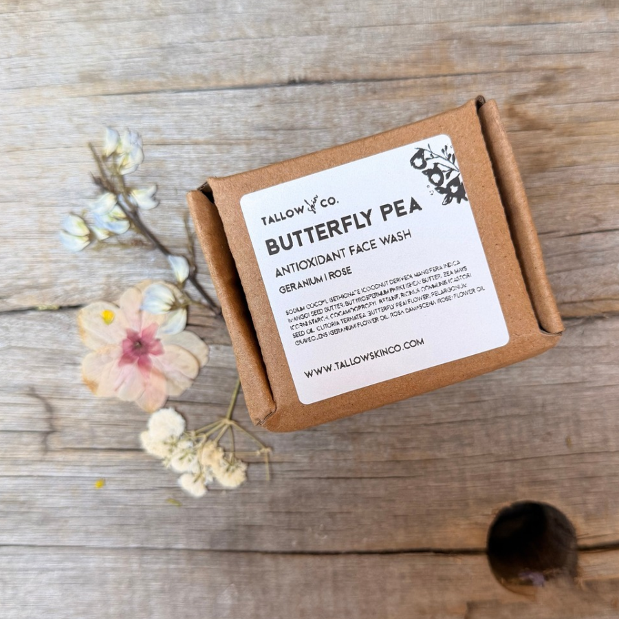 Butterfly Pea Antioxidant Face Wash by Tallow Skin Co. in a labeled kraft box, surrounded by dried botanical flowers on rustic wood.