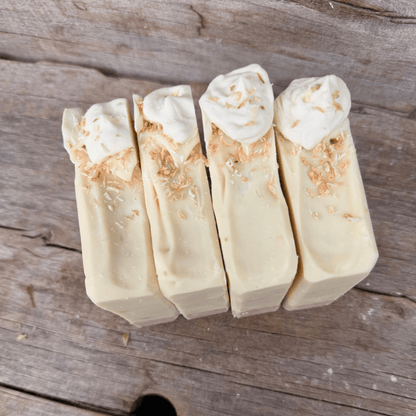 Overhead view of handmade Coconut Cream Pie tallow soap topped with piped soap and toasted coconut.