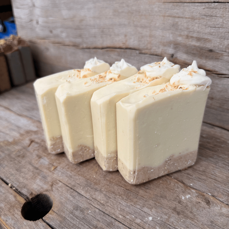 Close-up of Coconut Cream Pie tallow soap with a scrubby rolled oat and cocoa crust and hand-piped coconut cream top.