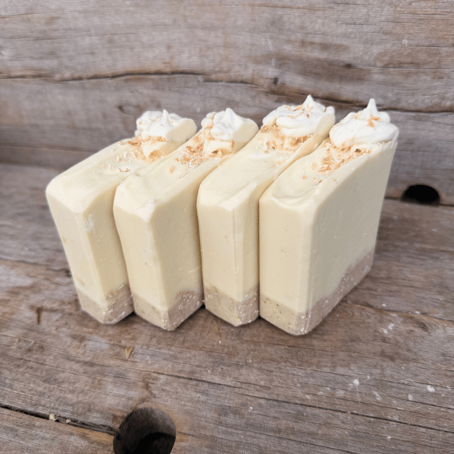 Side view of handmade Coconut Cream Pie soap showing the textured oat crust, creamy tallow soap, and toasted coconut topping.