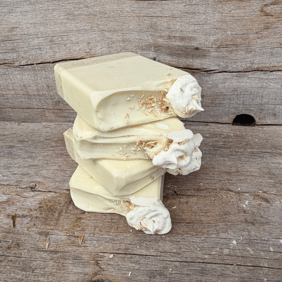 Stacked Coconut Cream Pie tallow soap bars showing the layered oat crust, creamy coconut soap, and toasted coconut topping.