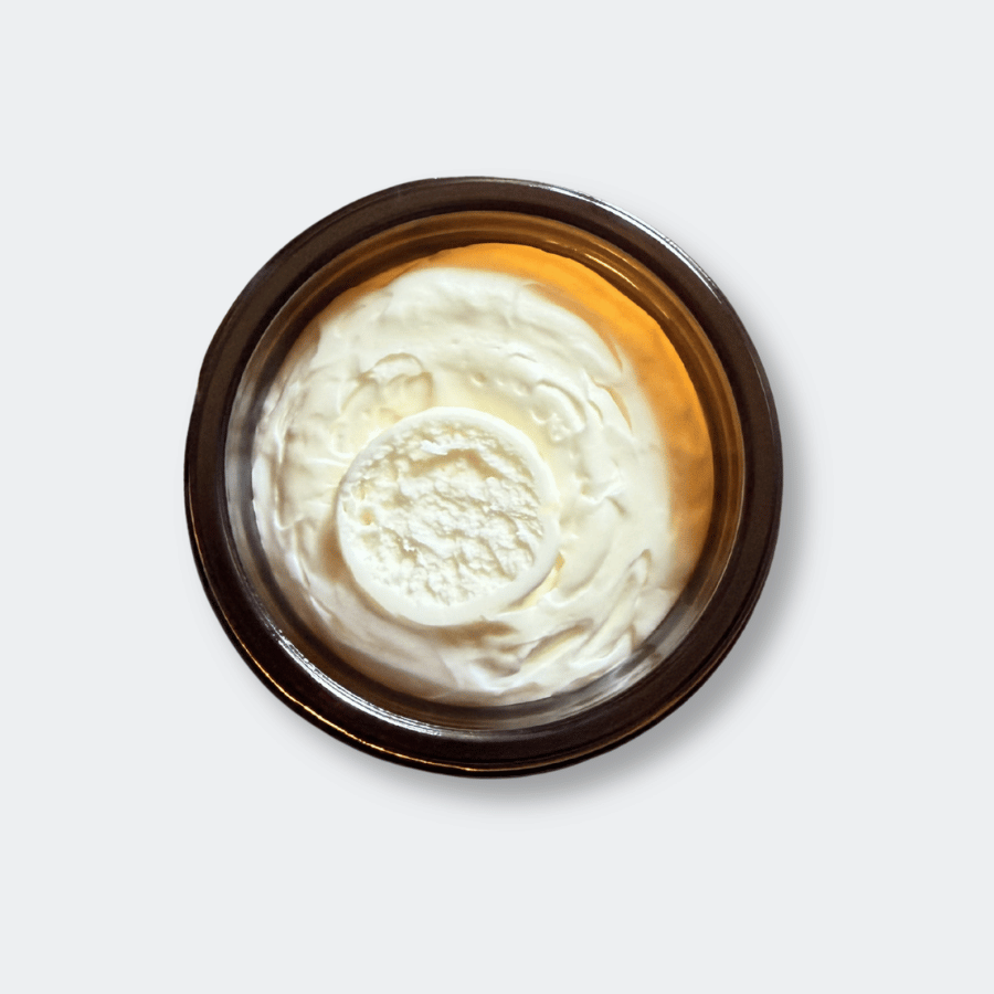 An open jar of tallow on a grey surface
