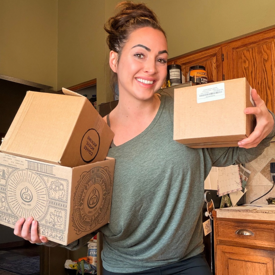 Tallow Skin Co. founder smiling while holding three mystery skincare gift boxes, available in small, medium and large sizes with twice the retail value.