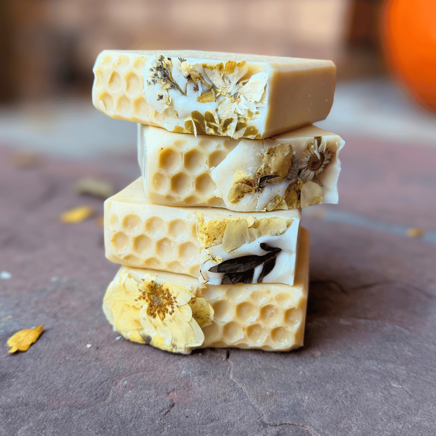 Four stacked honey-colored tallow soaps decorated with dried florals and textured honeycomb patterns