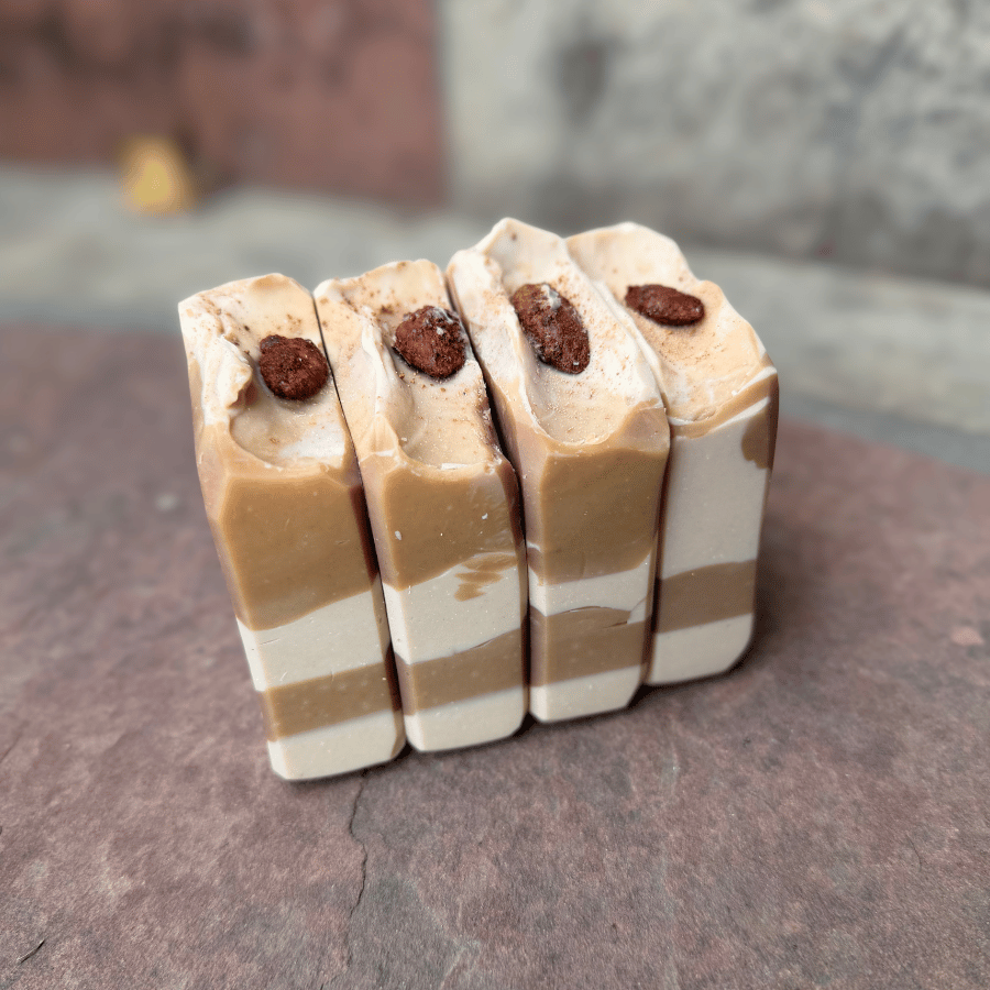 Four Almond Cookie grass-fed tallow soap bars standing upright, showcasing layered cream and cocoa swirls topped with candied cinnamon almonds.
