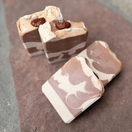 Four Almond Cookie grass-fed tallow soap bars arranged at different angles, highlighting cocoa swirls and decorative almond toppings.