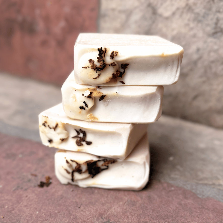 Four stacked Tobacco & Bay Leaf grass-fed tallow soap bars with creamy ivory coloring and real pipe tobacco accents, handcrafted by Tallow Skin Co.
