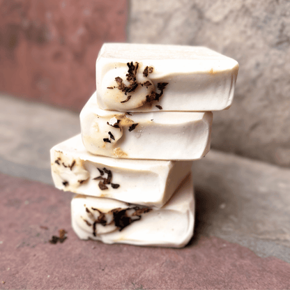 Four stacked Tobacco & Bay Leaf grass-fed tallow soap bars with creamy ivory coloring and real pipe tobacco accents, handcrafted by Tallow Skin Co.