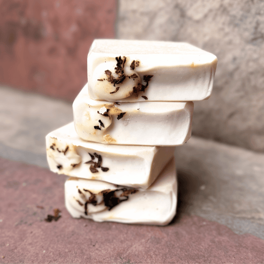 Four stacked Tobacco & Bay Leaf grass-fed tallow soap bars with creamy ivory coloring and real pipe tobacco accents, handcrafted by Tallow Skin Co.